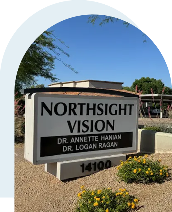 A sign for the northsight vision in front of some bushes